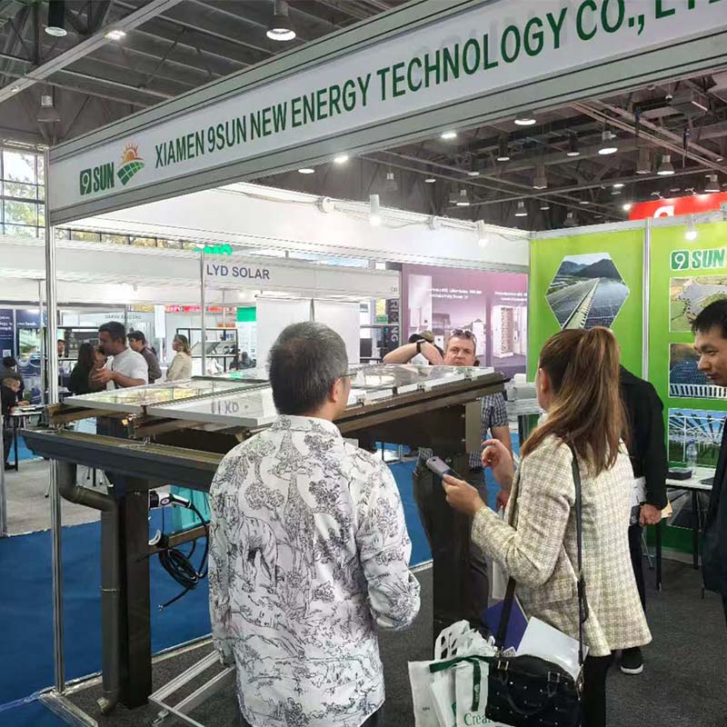 Visitors discussing a solar carport structure at the 9SUN booth, UzEnergy Expo 2026